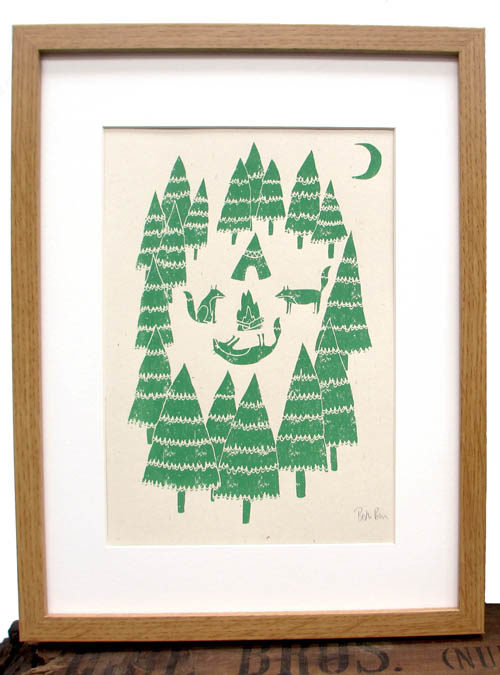 Picture of a framed art print of Foxes camping in the woods. 3 foxes surrounding a fire with a tipi in the woods