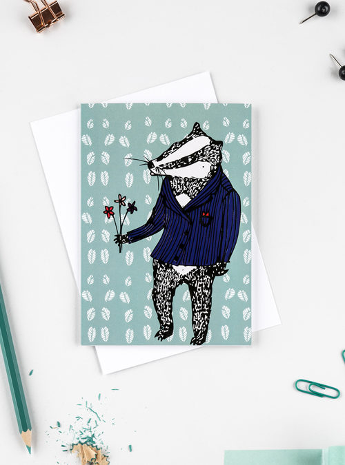 Greetings card-badger in a suit holding flowers with a green leafy background