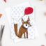 photograph of a greetings card featuring an orange fox holding a red balloon