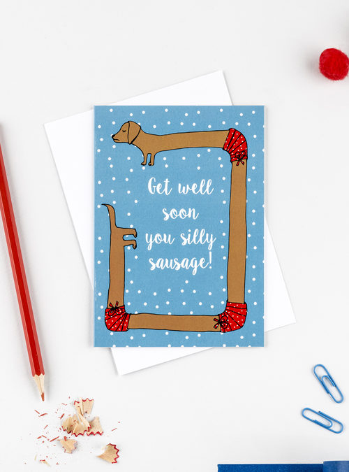 get well soon card featuring a sausage dog who has broken his body in 3 places with text saying 'Get well soon you silly sausage'