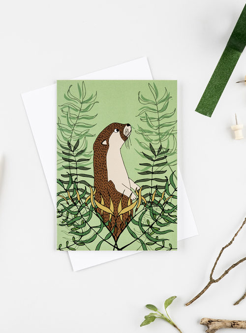 Photo of an otter and kelp card. Green card featuring an illusrration of an otter surrounded by kelp.