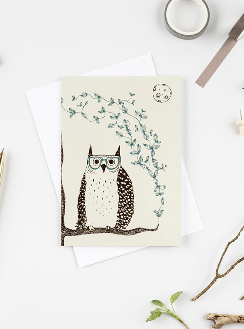 photo of a card showing an illustration of an owl on a branch wearing glasses