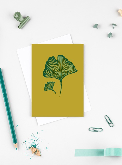 Ginko card. Green ginko leaves on a mustard background